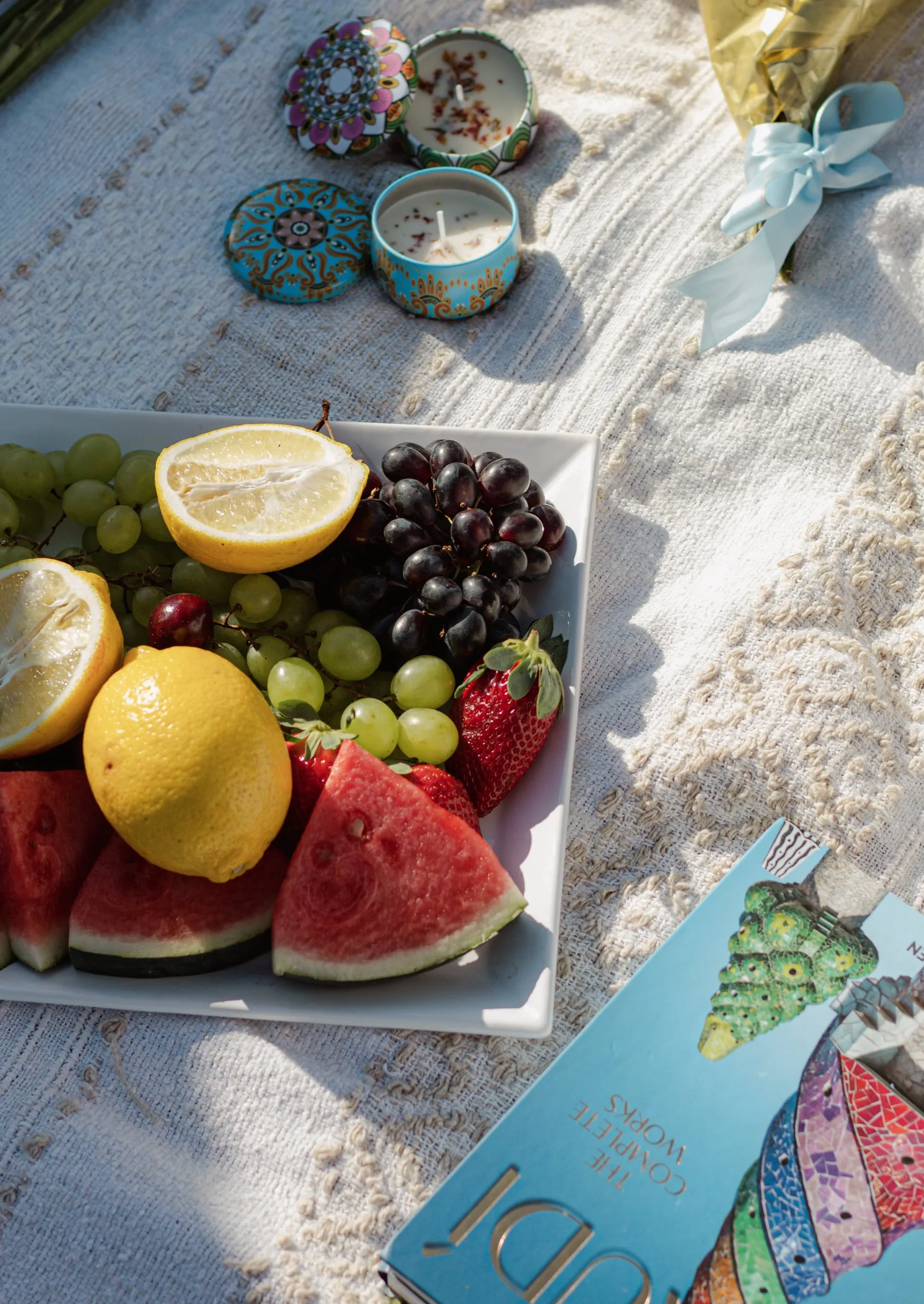 Piquenique com frutas, limões e velas decorativas sobre a toalha