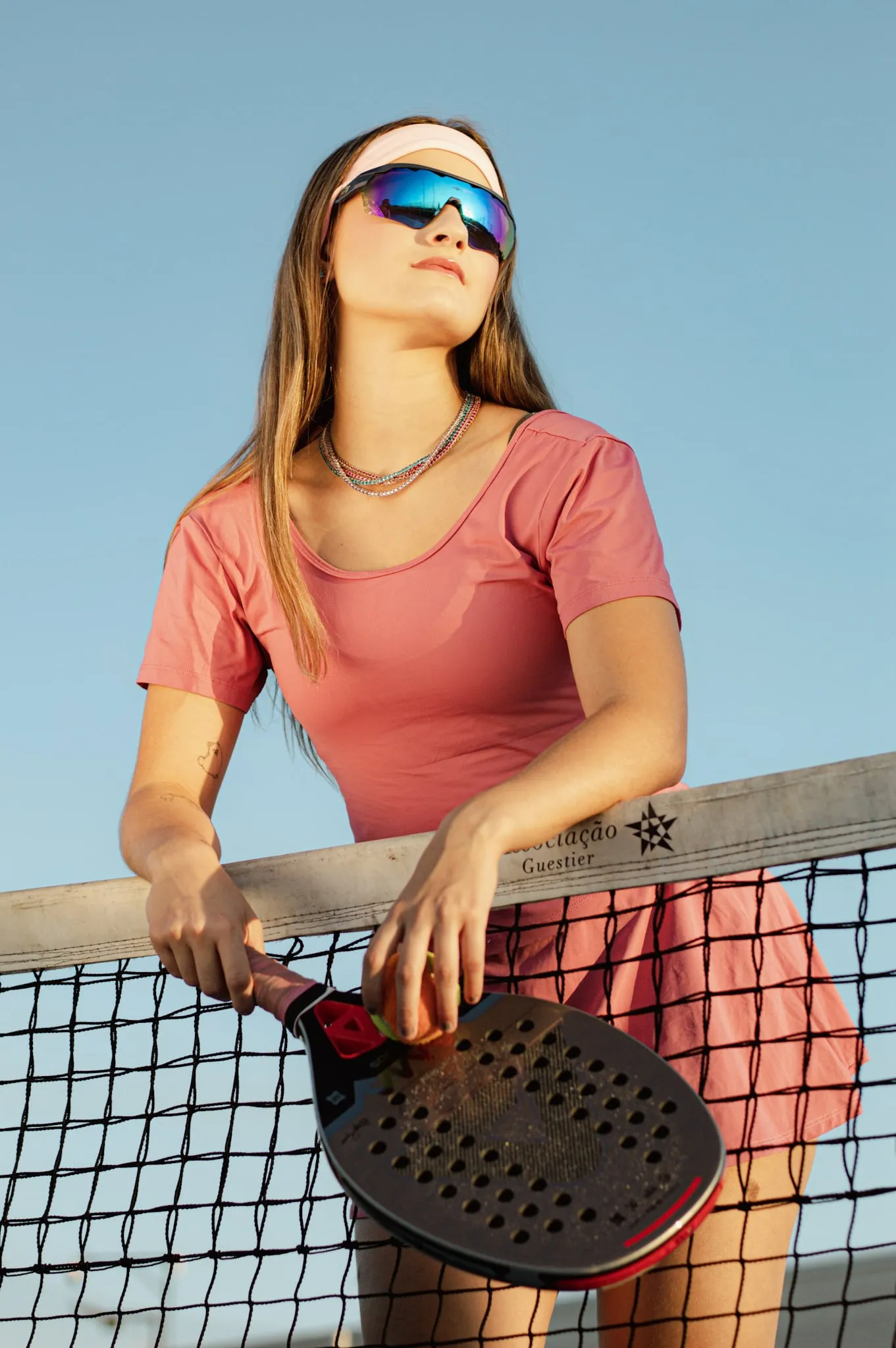 Modelo jogando tênis ao ar livre, usando joias da coleção