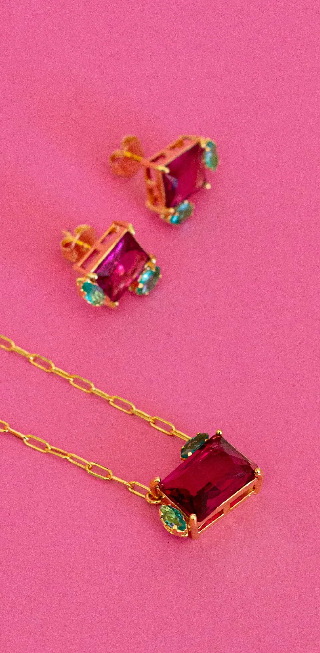 Colar com pedras vermelhas sobre fundo rosa